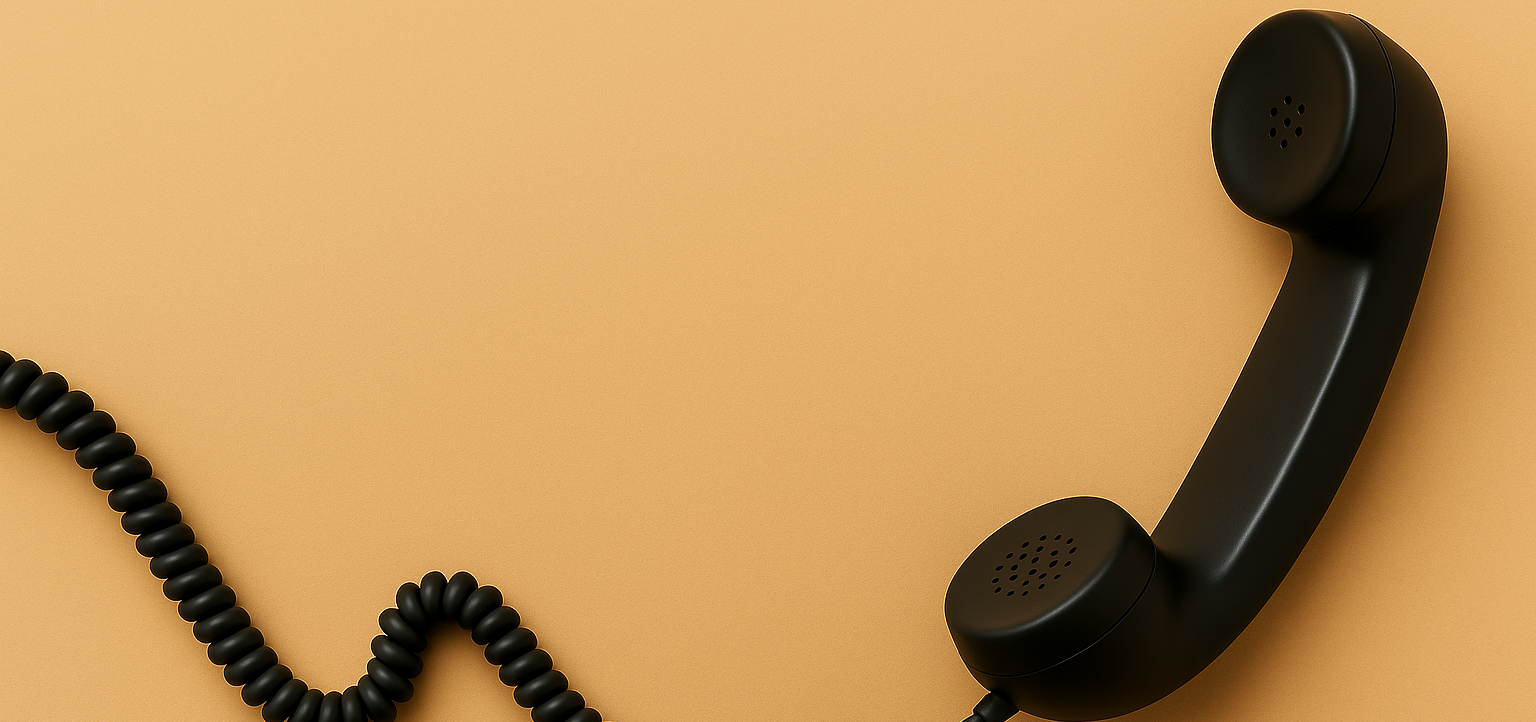 Schwarzer Telefonhörer auf orangem Hintergrund mit spiralförmigem Kabel.